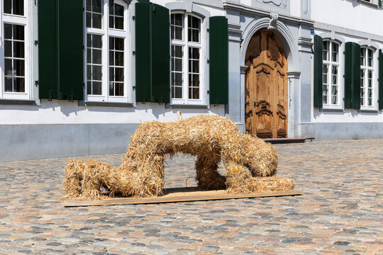 Basel, Switzerland - June, 19.2023: Straw figure showing emotional gestures on the Munster Square from the Art Parcours Event.