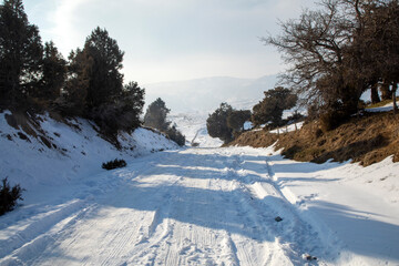 Snowy steep road on a mountain pass in Samarkand.