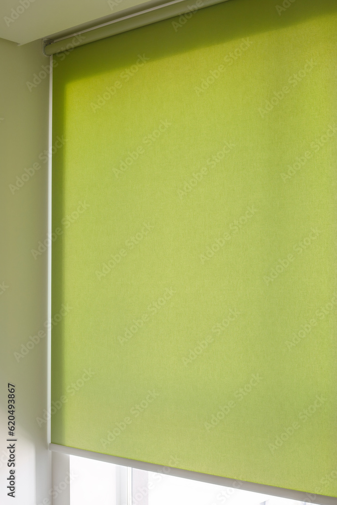 Poster roller blinds automatic close-up on the window. selective focus. motorized shades. green color curta