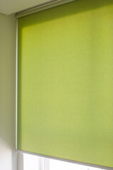 Roller blinds automatic close-up on the window. Selective focus. Motorized shades. Green color...