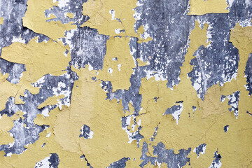 Cracked yellow paint on cement wall