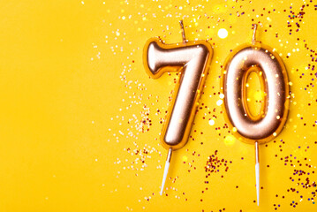 70 years celebration. Greeting banner. Gold candles in the form of number forty on yellow...