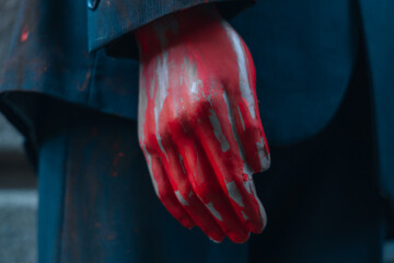 A bloody hand on a mannequin of a man in a suit. Halloween.