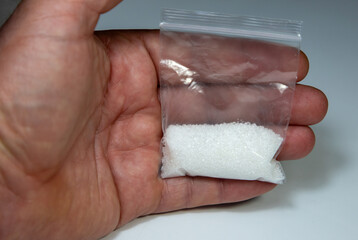 A bag with white powder in a hand