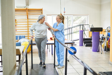 Physiotherapist assisting senior woman in movement therapy