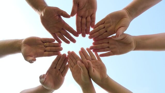 Joined hands as a team. Business teamwork. Close up group of friends meeting join hands together. Diversity people. Partnership volunteer community. Diverse multiethnic Partners. Blue Sky background