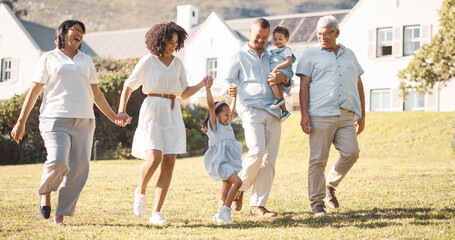 Holding hands, children and a blended family walking in the backyard of their home together during summer. Grandparents, parents and kids on grass in the garden of a house for bonding during a visit