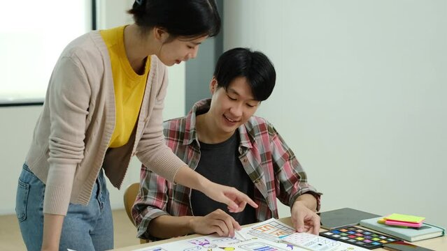 Asian man creative designer explaining project detail to his colleagues during meeting in office