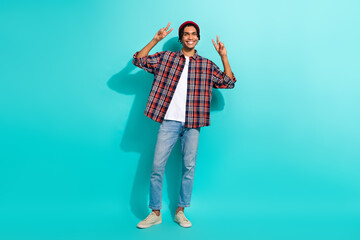 Full length portrait of funky cheerful young person hands fingers demonstrate v-sign isolated on turquoise color background