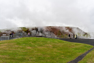 Krysuvik, Seltun, Iceland - 06.26.2023: Tourists in geothermal area steaming sulfur hot springs of...