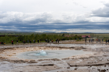 Iceland - 06.30.2023: Tourists watching Strokkur geyser about to erup