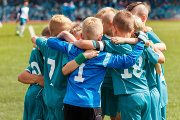 Powerful Team Unity: Children Huddling in Sports Team, Embracing Friendship and Camaraderie on a...