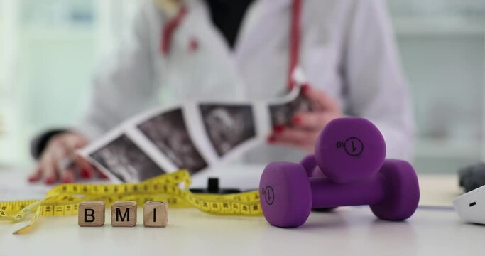 Cube with inscription BMI with dumbbells and measuring tape. Medical concept diet and health