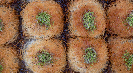 close up turkish dessert kadayif. shredded wheat dessert with pistachio filling