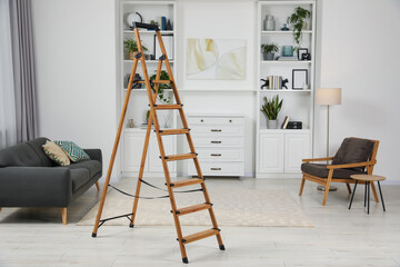 Wooden folding ladder on soft carpet in stylish room