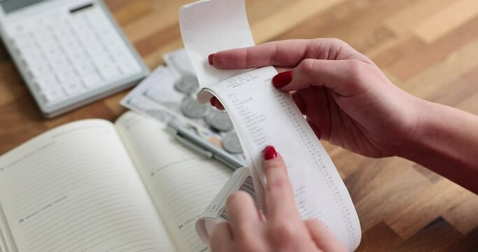 Woman checks cash receipt and counts purchases. Cost control and family budget