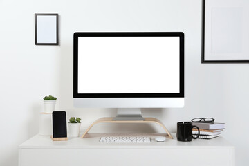 Cozy workspace with computer, smartphone and stationery on wooden desk at home