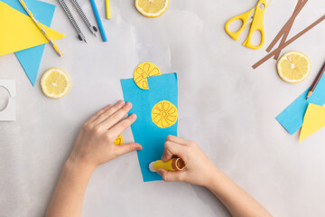 Paper lemonade with lemons. Children at home. Hands making DIY summer crafting. Kindergarten ideas step by step.