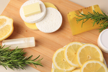 Lemon face cleanser. Fresh citrus fruits, rosemary and personal care products on wooden board, above view