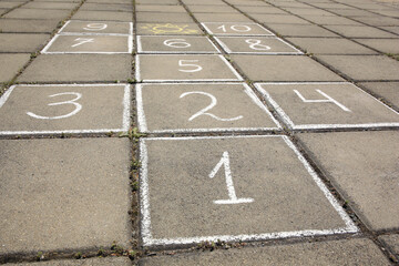 Fototapeta premium Hopscotch drawn with white chalk on street tiles outdoors