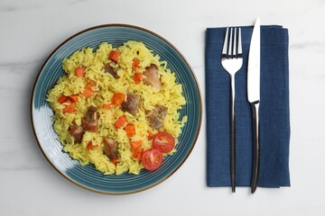 Delicious pilaf with meat served on white marble table, flat lay