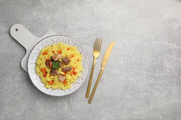 Delicious pilaf with meat served on light grey table, flat lay. Space for text