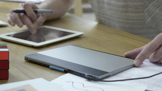 Close up shot of creative designer drawing sketche, blueprint or prototype on his drawing pad. Animator is working on new model product project or creating new logo branding for company.