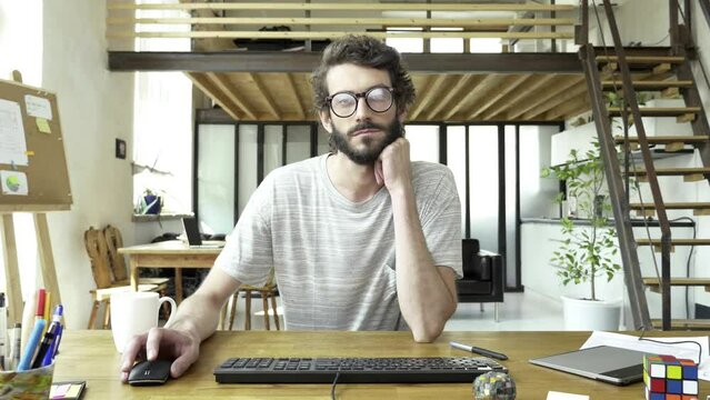 Adult man is working in front of computer for a very long time. He is a little bit tired and not motivated. Maybe he is student praparing for an exam, maybe he cannot find answer for the hard question