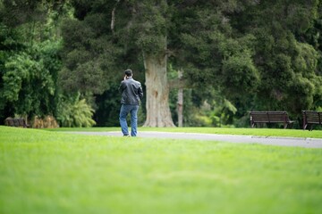 couple walking in a garden. man and woman walk in nature under trees surrounded by plants. family together in a park in spring time