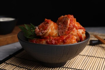 Delicious stuffed cabbage rolls cooked with homemade tomato sauce on table, closeup
