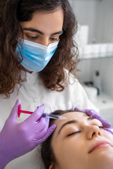 Young woman receiving hair mesotherapy injections from a professional doctor.