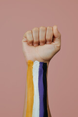 clenched fist and non-binary flag in their arm - 620522088