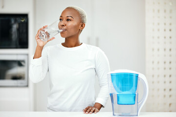 Woman, filter and drinking water for health at home for a healthy lifestyle, diet and nutrition....
