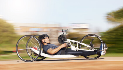 Cycling, fitness and speed with man and handcycle in nature for training, sports and challenge. Exercise, workout and motion blur with person with a disability in park for cardio and health