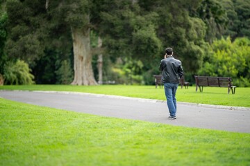 couple walking in a garden. man and woman walk in nature under trees surrounded by plants. family together in a park in spring time