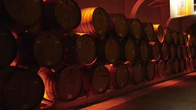 Wine or cognac barrels in cellar of winery, Wooden wine barrels in perspective. wine vaults. vintage oak barrels of craft beer or brandy.