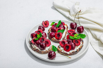 Fresh bread sandwiches with sweet cherry, cream cheese and mint leaves. Morning breakfast concept