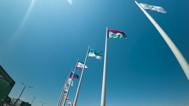 Flags in blus sunny sky on Medal Square of olympic park in Sochi city