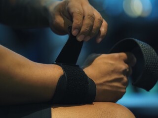 Close up hands men holding and putting arm wrap bandages weight kilograms, arm dumbbell, fitness, gym, training, power, sport, health, exercise  - obrazy, fototapety, plakaty