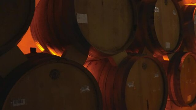 Wine or cognac barrels in cellar of winery, Wooden wine barrels in perspective. wine vaults. vintage oak barrels of craft beer or brandy.