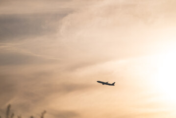 夕暮れ時に離陸して爽快に飛行する飛行機のシルエット