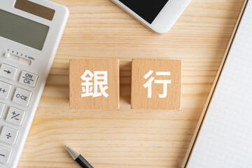 銀行と書かれたブロック、電卓、スマホ、ノート