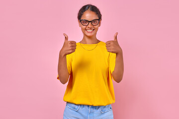 Young smiling beautiful Indian woman teen in glasses shows thumbs up answering question how are you...