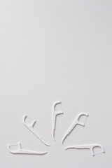 Many white dental toothpicks with dental floss on white background - obrazy, fototapety, plakaty