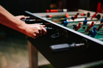 man plays table football. Detail of man's hands playing the kicker - obrazy, fototapety, plakaty