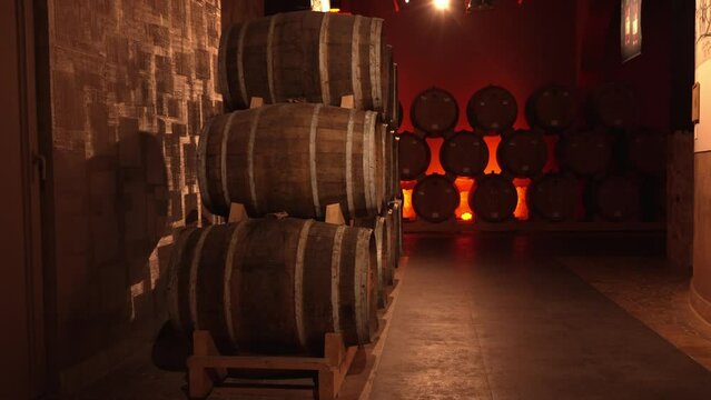 Wine or cognac barrels in cellar of winery, Wooden wine barrels in perspective. wine vaults. vintage oak barrels of craft beer or brandy.