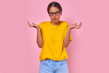 Young expressive Indian woman teenager spreads hands to sides and looks at screen with...