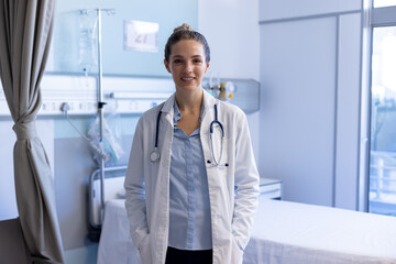 Portrait of happy caucasian female doctor wearing medical lab coat and stethoscope at hospital