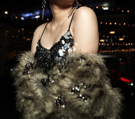 Woman in Sparkle bling bling party dress with faux fur coat and crystal earrings