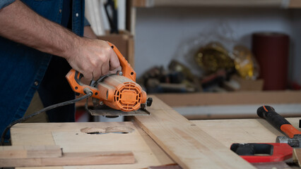 Male carpenter working with skill in carpentry workshop. Professional joiner works with tools in woodworking. Closeup mature woodworker making or repairing furniture. Craftsmanship industry